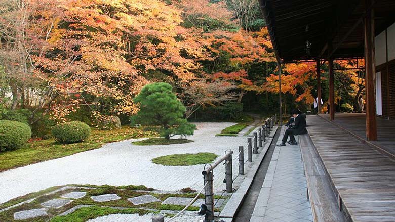 ensam man vid en stenträdgård i Kyoto