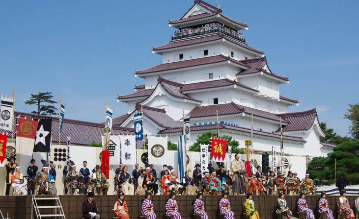 slottet i Aizu med uppklädda japaner i kimono